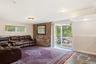 Exposed brick accent wall, recessed lighting, sliding glass door, multiple windows, and flagstone flooring