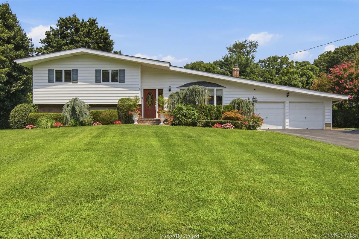 White siding exterior with a red entry door, bay window, and attached two-car garage