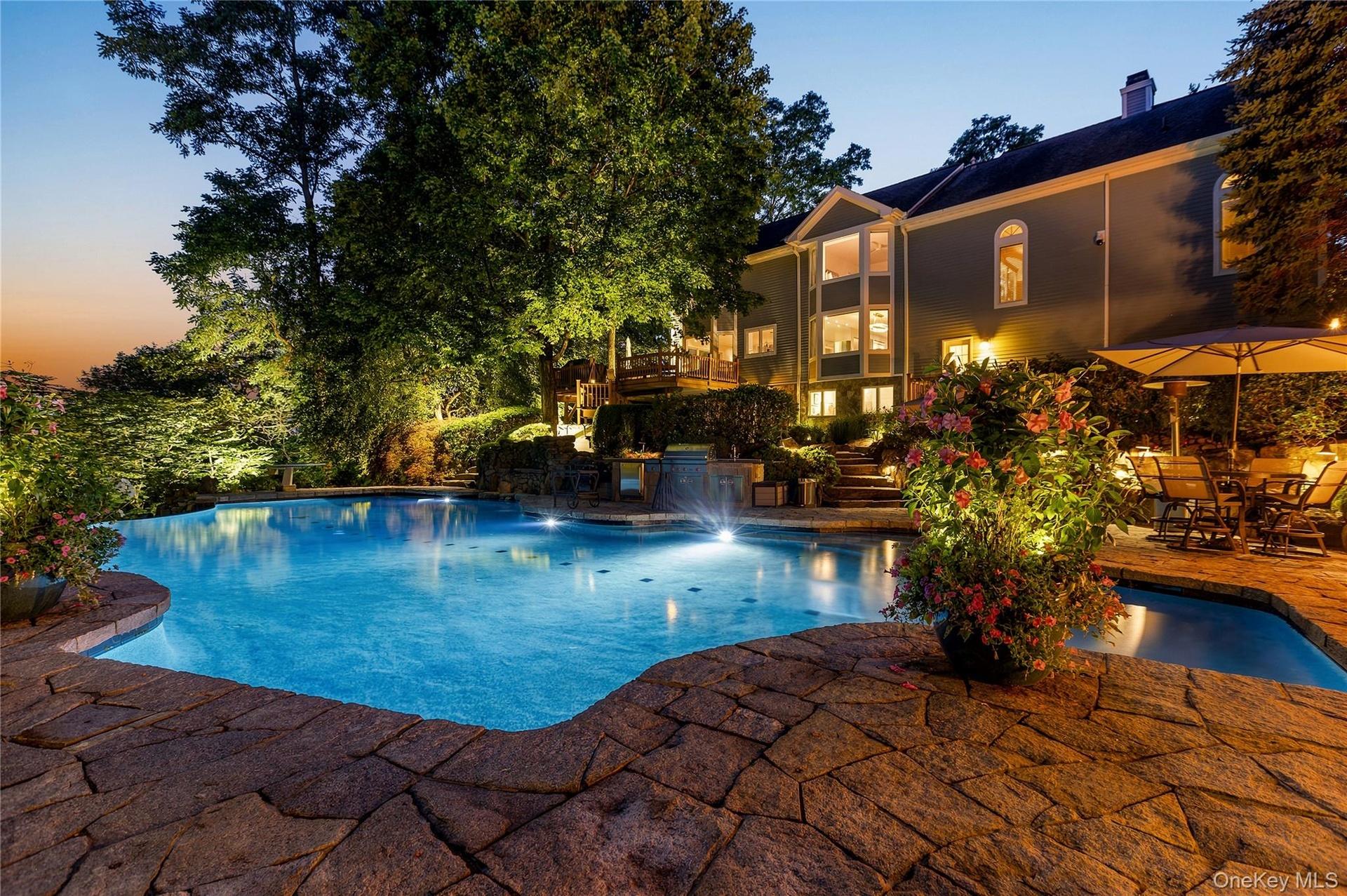 Twilight at 6 Canterbury Ct. in the resort-like property including pool with infinity edge, spa, patio, outdoor kitchen and firepit.