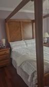 Wood-finish flooring, large window, closet and ceiling fan.