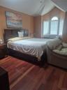 Master Bedroom with wood-finish flooring, recessed lighting, a vaulted ceiling and arched bay window