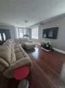 Hardwood flooring, crown molding, bay window, recessed lighting, and crystal chandelier