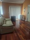Master Bedroom with hardwood flooring throughout, vertical blinds, and an arched window with horizontal blinds