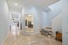 Polished stone flooring, recessed lighting, and a multi-level staircase with carpeted treads