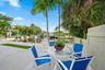 Concrete patio with a water frontage, mature palm trees, and a built-in privacy wall