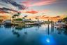 Waterfront property with extensive boat docks, mature palm trees, and a manicured lawn