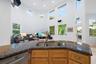 Kitchen island with a double basin sink, granite countertop, and wood-finish cabinetry