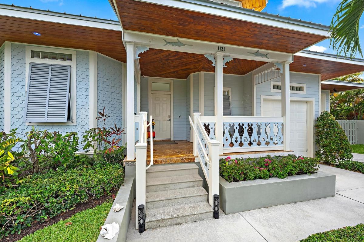 Front entry featuring a covered porch with a wood-finish ceiling, decorative railing, and concrete steps