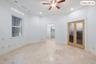 Recessed lighting, ceiling fan, transom window, natural wood-finish French doors, and tile flooring