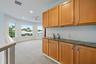 Wet bar with natural wood cabinetry and a stone countertop