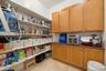 Integrated pantry storage featuring a combination of open shelving, upper cabinetry, lower cabinetry, and a countertop surface
