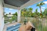 Outdoor balcony with a sturdy railing, concrete flooring, and an exterior window