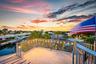 Spacious rooftop patio featuring string lighting, aluminum railings, and canal access with multiple boat docks