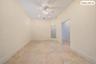 Vaulted ceiling with a ceiling fan, recessed lighting, tile flooring, and an open doorway