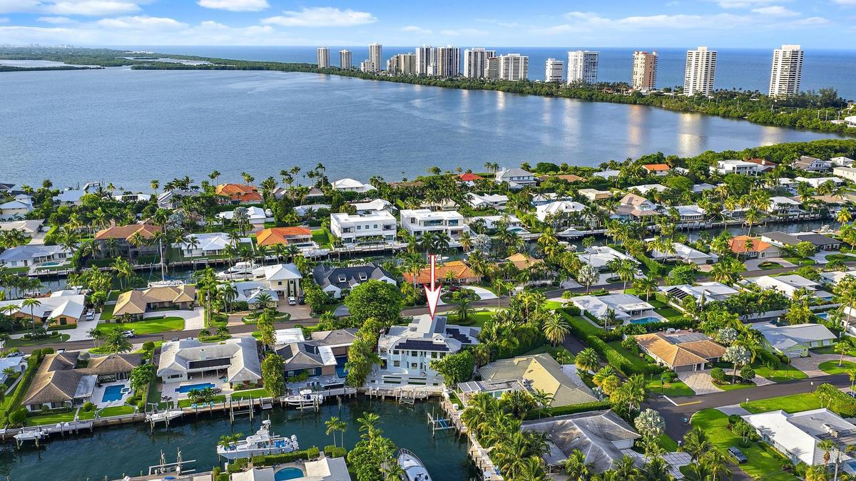 Waterfront property featuring a private boat dock and mature tropical landscaping