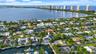 Waterfront property featuring a private boat dock and mature tropical landscaping