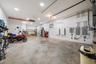 Spacious garage featuring concrete flooring, recessed lighting, built-in cabinetry, and integrated electrical panels
