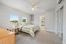 Recessed windows, ceiling fan, carpet flooring, mirrored closet doors, and a wall-mounted air conditioning unit