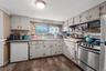 Kitchen featuring wood-finish flooring, white cabinetry, stainless steel range, dishwasher