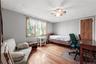 Wood-finish flooring, a ceiling fan with light fixture, and a window with wood trim