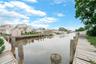 Waterfront property with extensive wooden dockage, mature trees, and canal access