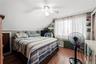 Unit 1 BedroomWood-finish flooring, ceiling fan, window-mounted air conditioning unit, and built-in shelving