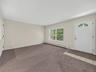 The expansive finished lower-level living area is filled with natural light and features its own exterior entrance, creating an exceptionally versatil