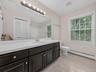 The spacious upstairs bath features a large vanity, abundant natural light and plenty of room for busy morning routines.