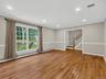 Oversized windows and an open layout fill the living space with natural light, creating an inviting setting for both everyday living and entertaining.