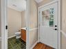 The first-floor powder room and nearby rear entrance add everyday functionality and easy access to the deck.