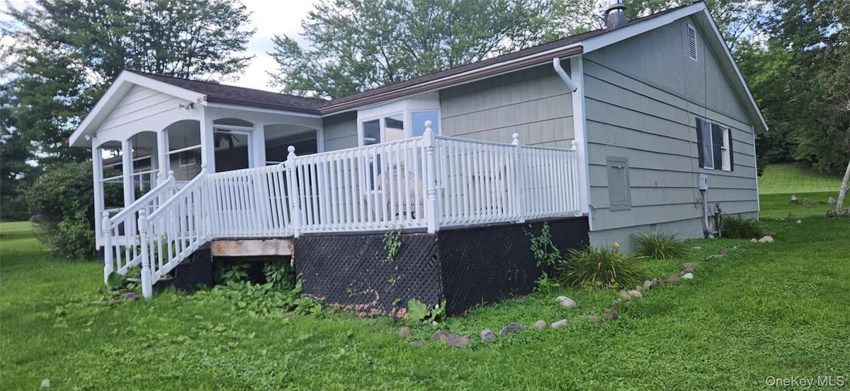 Exterior featuring light green siding, white deck railing, and a screened-in porch