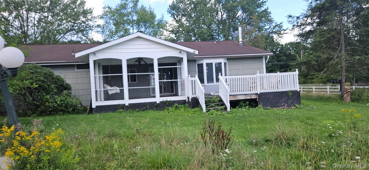 Screened porch with white railings, a bay window, and an exterior deck