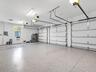 Oversized multi-car garage with epoxy flooring, high clearance for equipment, and built-in storage potential