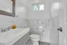 Bathroom featuring tile walls, vanity, and toilet