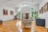 Entryway featuring light wood finished floors, baseboard heating, ornamental molding, a chandelier, and high vaulted ceiling
