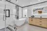 Full bathroom featuring vanity, a marble finish shower, and a freestanding bath