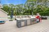 Deck featuring a sink, view of wooded area, and an outdoor living space