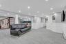 Living room with decorative columns, a decorative wall, recessed lighting, wainscoting, and a baseboard heating unit