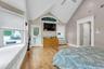 Bedroom with light wood-style flooring, a baseboard radiator, a ceiling fan, baseboards, and high vaulted ceiling