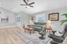 Spacious and light-filled living room with high ceilings, offering a warm and inviting setting for relaxing or entertaining.