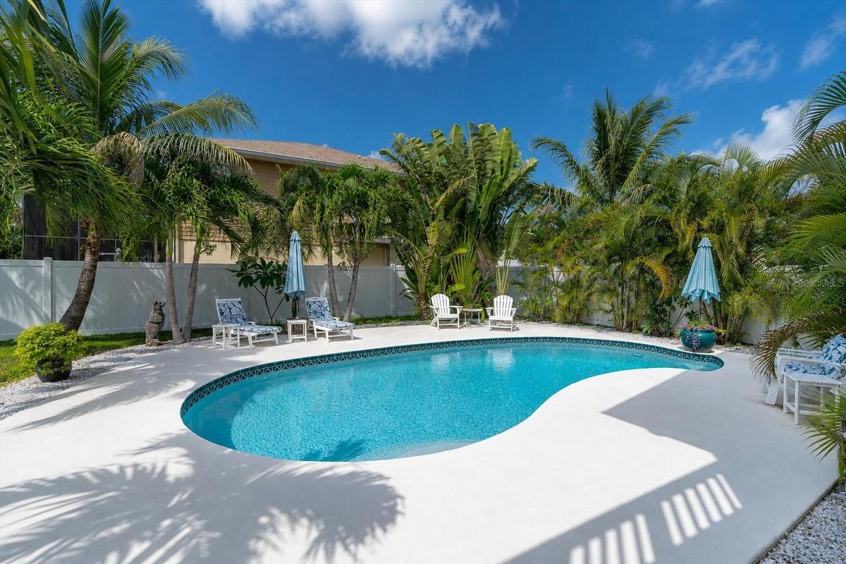 The expansive backyard offers a lush tropical setting, fully fenced for privacy & creating a peaceful retreat for relaxing & entertaining.