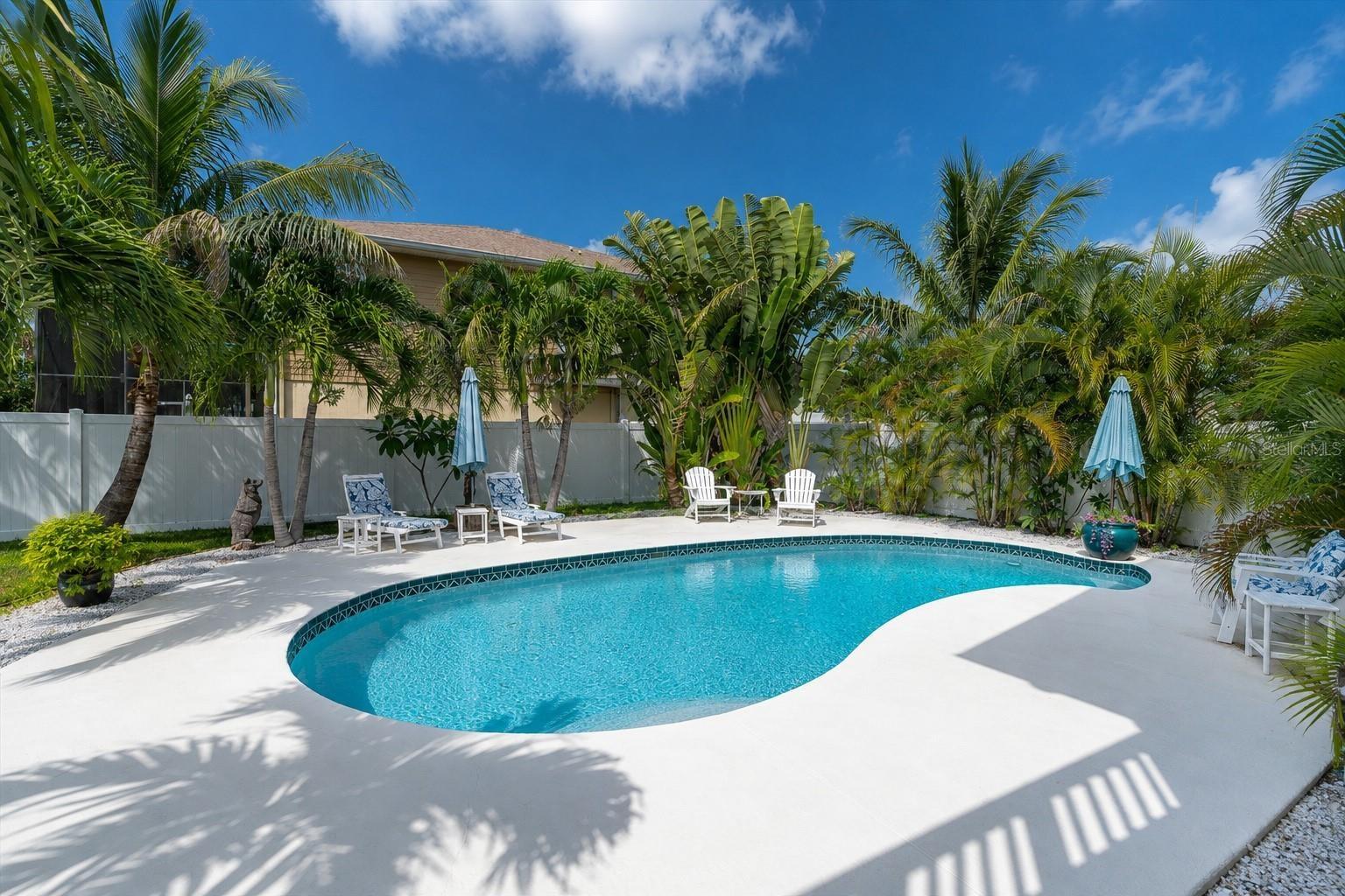 The expansive backyard offers a lush tropical setting, fully fenced for privacy & creating a peaceful retreat for relaxing & entertaining.