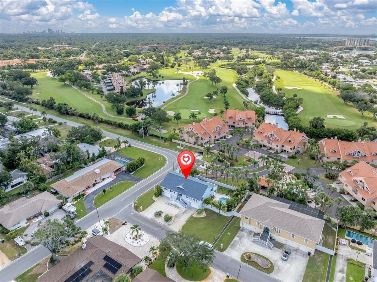 Aerial view overlooking the home, surrounding residences, and the beautiful Pasadena Yacht & Country Club golf course.