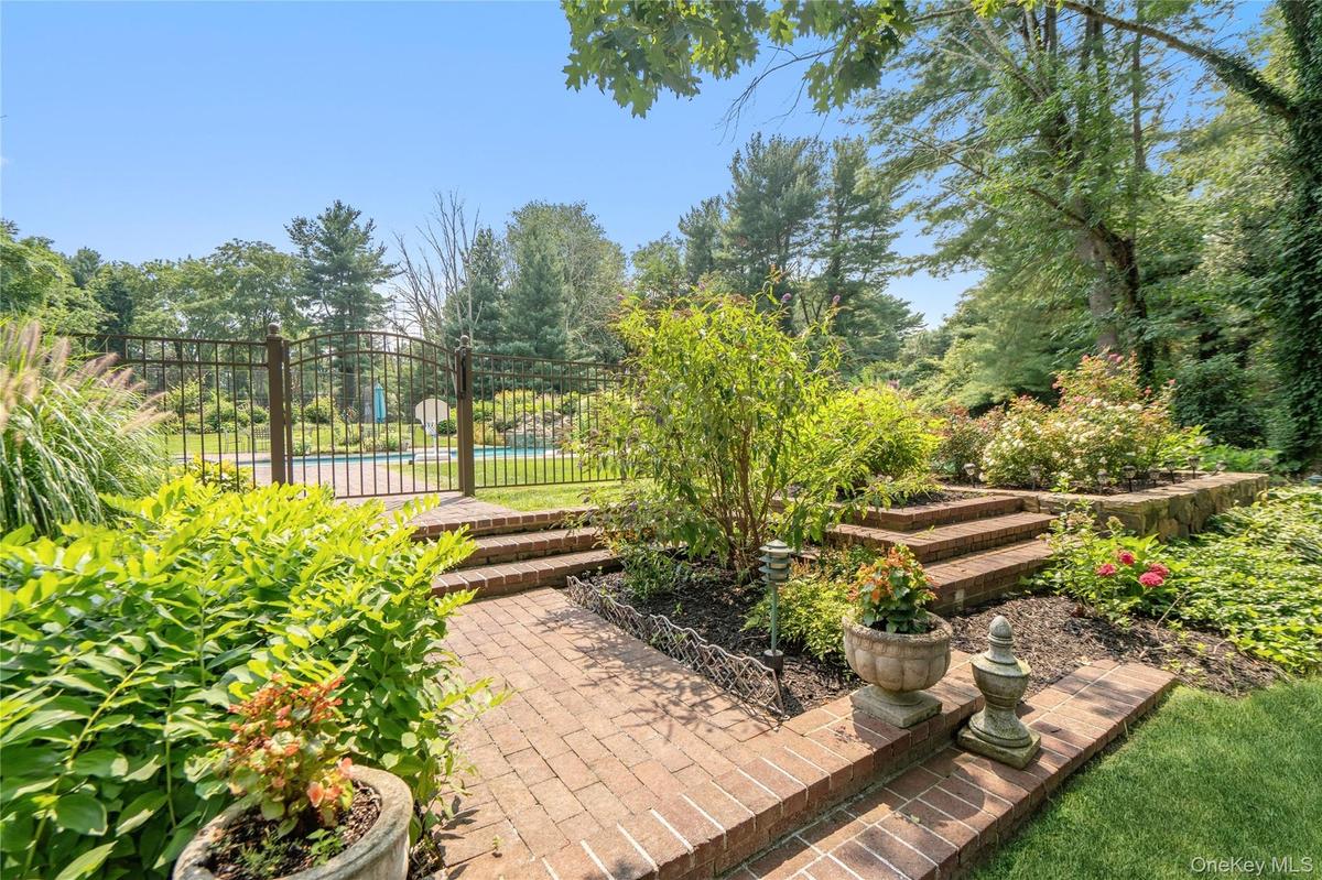 luscious landscaping leads to salt water pool and pool house