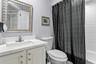 The en-suite bath is neatly designed for comfort, privacy, and ease.