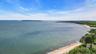 Expansive waterfront with a sandy beach and a distant island