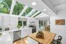 Kitchen with vaulted ceiling and integrated skylights, white cabinetry, stainless steel appliances, a wood-finish island, and recessed lighting
