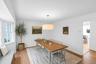 Hardwood flooring, bay window, contemporary chandelier, white walls, and beadboard wainscoting