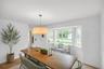 Hardwood-finish flooring, white walls, and a large bay window