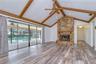 Open gathering space featuring beamed vaulted ceilings and a cozy wood-burning fireplace